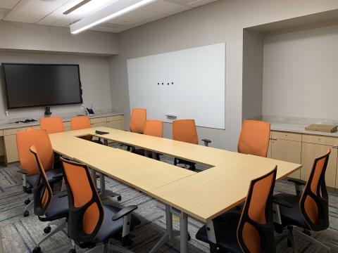 An image of the board room setup of Meeting Room 1, with a large whiteboard and video screen visible on the walls.