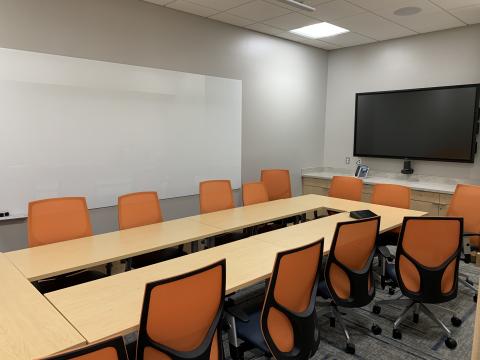 Board room setup of Meeting Room 2 with a large white board and screen visible on the walls.