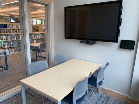 Image of Study Room setup with four chairs around a table below a large screen mounted on the wall.