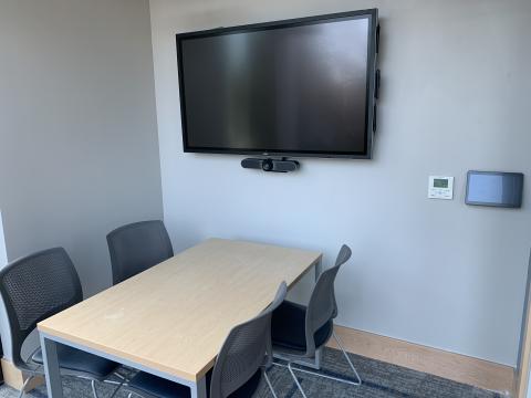 Image of Study Room 2B showing a table with four chairs with a screen and control panel mounted on the wall.
