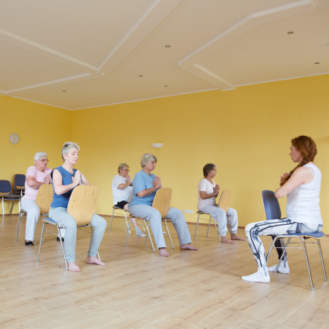 A stock picture of a chair yoga class