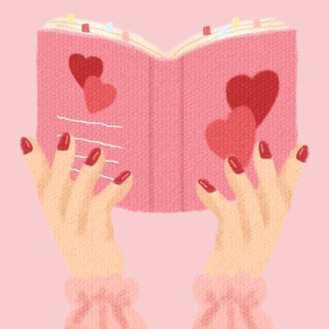 A pair of hands with red painted nails holding a pink book with hearts on it.