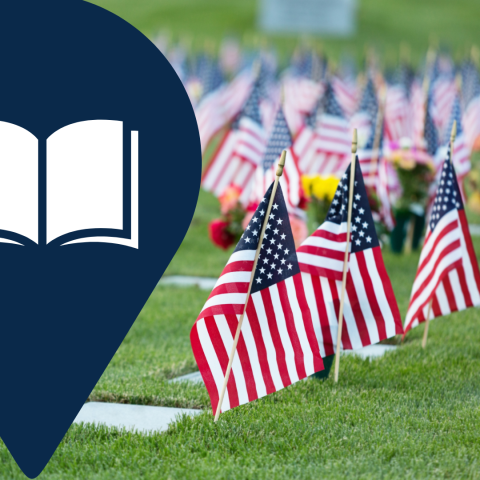 A picture of American flags planted at gravestones in a cemetery 