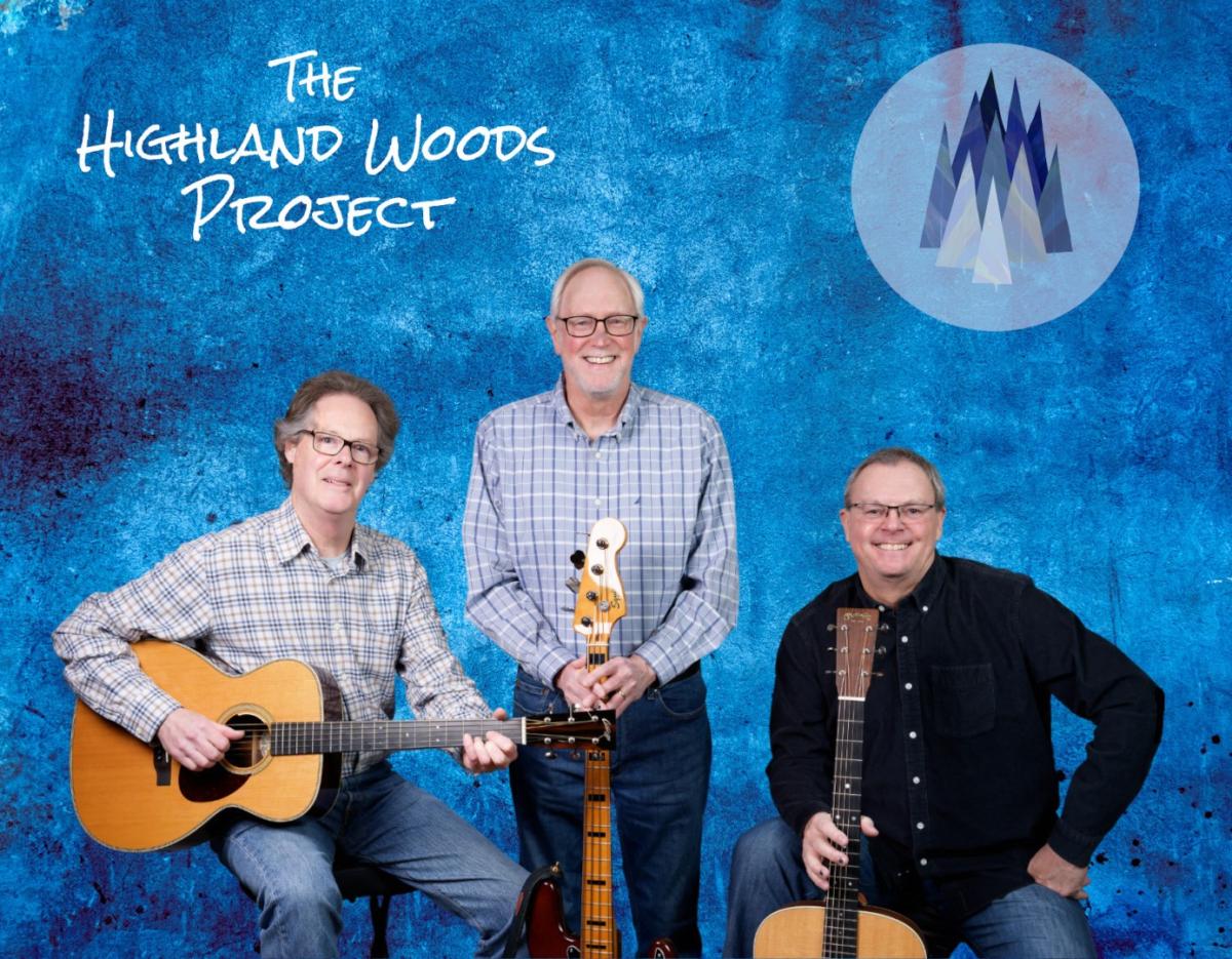 A photo of 3 men holding guitars in front of a blue background.