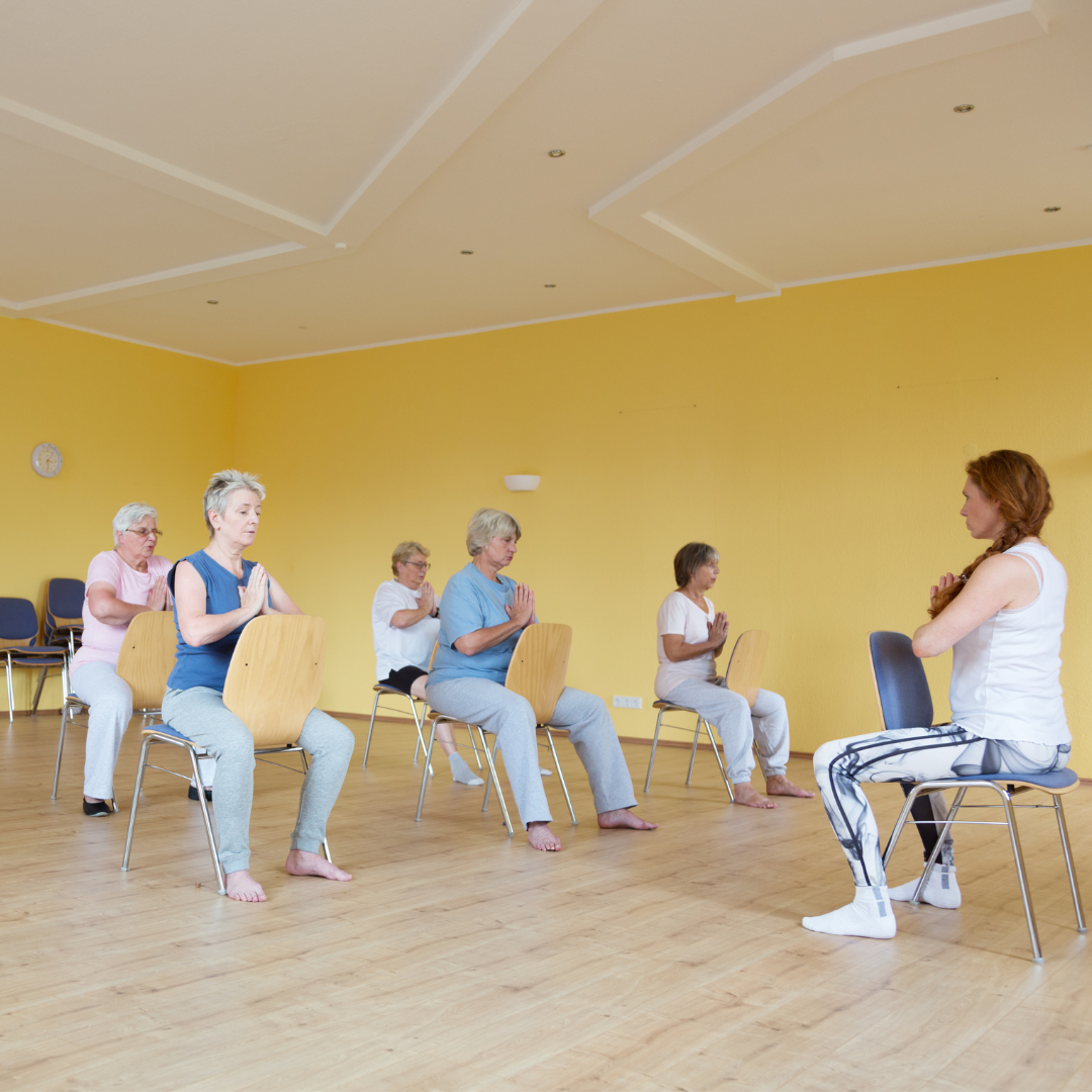 A stock picture of a chair yoga class